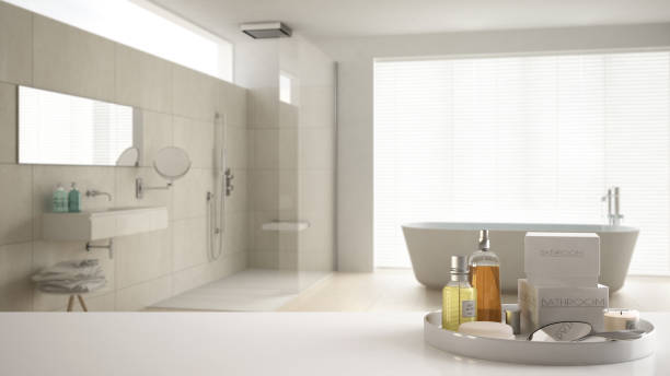 istock Spa, hotel bathroom concept. White table top or shelf with bathing accessories, toiletries, over blurred cream minimalist bathroom, modern architecture interior design 1007705128