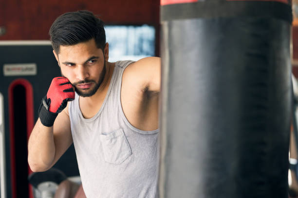 istock Boxer striking the punching bag at gym 1007705812