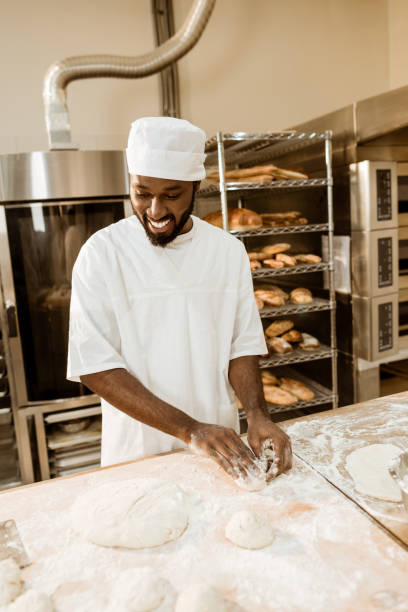 istock smiling african american baker preparing raw dough for pastry on baking manufacture 1007706162