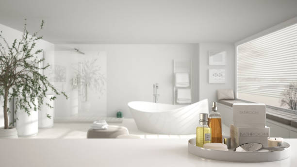 istock Spa, hotel bathroom concept. White table top or shelf with bathing accessories, toiletries, over blurred large minimalist bathroom, modern architecture interior design 1007706208
