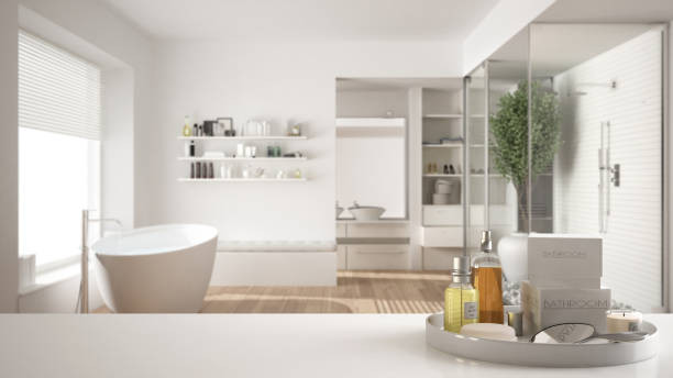 istock Spa, hotel bathroom concept. White table top or shelf with bathing accessories, toiletries, over blurred minimalist bathroom, modern architecture interior design 1007706412