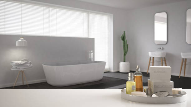 istock Spa, hotel bathroom concept. White table top or shelf with bathing accessories, toiletries, over blurred minimalist bathroom, modern architecture interior design 1007706448