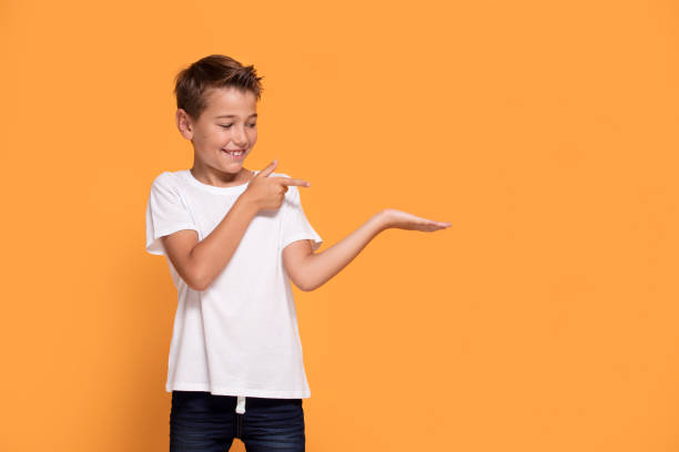 istock Young emotional little boy on orange studio background. 1007706538