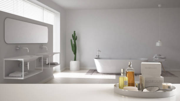 istock Spa, hotel bathroom concept. White table top or shelf with bathing accessories, toiletries, over blurred minimalist bathroom, modern architecture interior design 1007706570