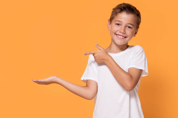 istock Young emotional little boy on orange studio background. 1007706582