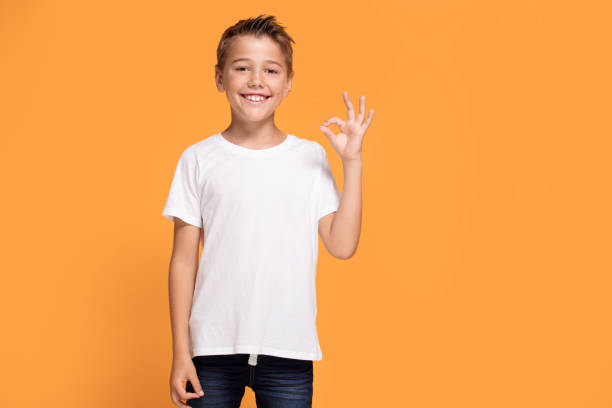istock Young emotional little boy on orange studio background. 1007708842