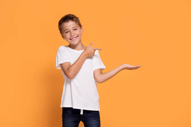 istock Young emotional little boy on orange studio background. 1007708866