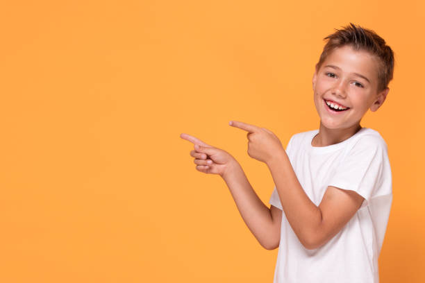 istock Young emotional little boy on orange studio background. 1007708908