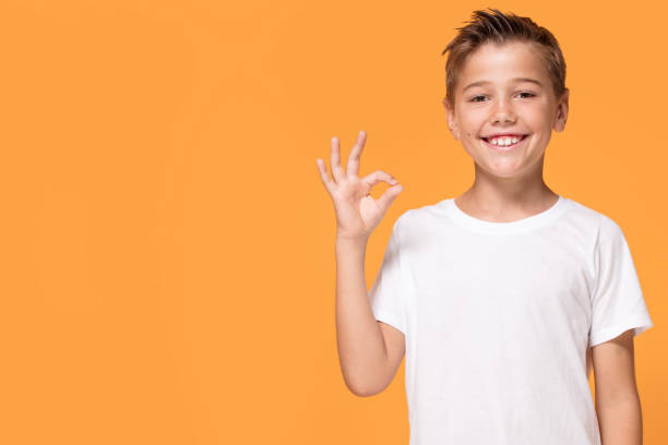 istock Young emotional little boy on orange studio background. 1007708920