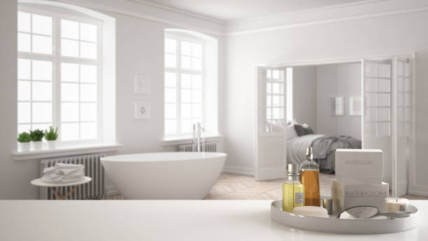 istock Spa, hotel bathroom concept. White table top or shelf with bathing accessories, toiletries, over blurred vintage bathroom with bedroom, modern architecture interior design 1007708964