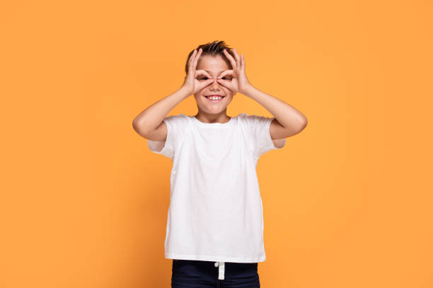 istock Young emotional little boy on orange studio background. 1007709196