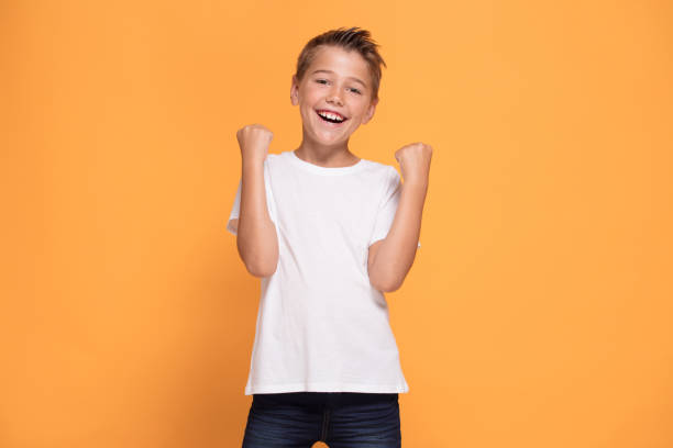 istock Young emotional little boy on orange studio background. 1007709298