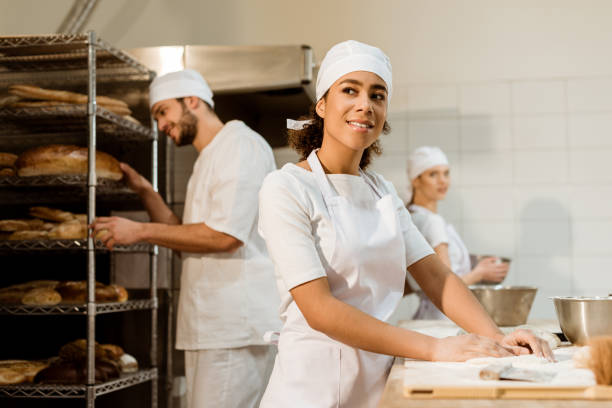 istock happy female baker working at baking manufacture 1007709456