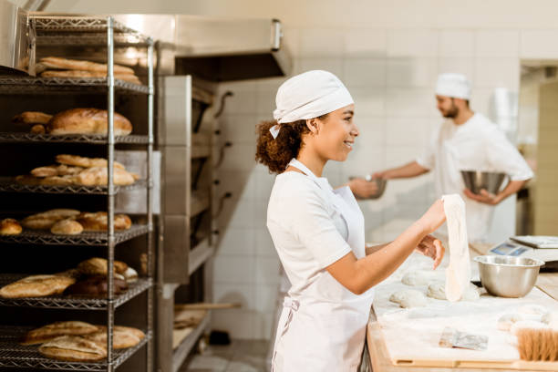 istock female african american baker kneading dough at baking manufacture 1007710010