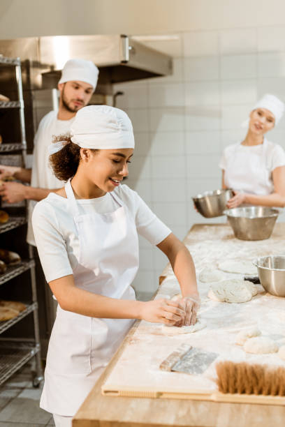 istock multiethnic team of bakers working together at baking manufacture 1007712900
