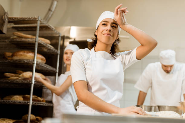 istock happy and tired female baker working at baking manufacture 1007716844
