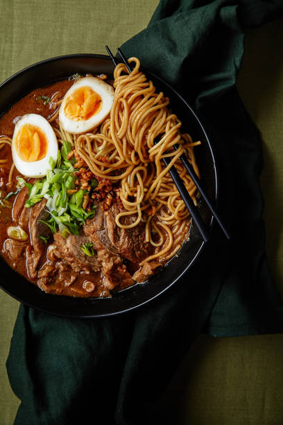 istock Japanese ramen with pork belly, mushrooms and marinated eggs on green linen tablecloth 1007720596