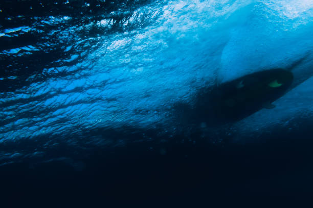 istock Underwater barrel wave in tropical ocean and surfboard 1007720610