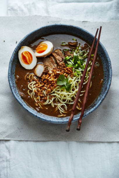 istock Japanese ramen with pork belly, mushrooms and marinated eggs served in blue handmade ceramic bowl garnished with chives 1007722770