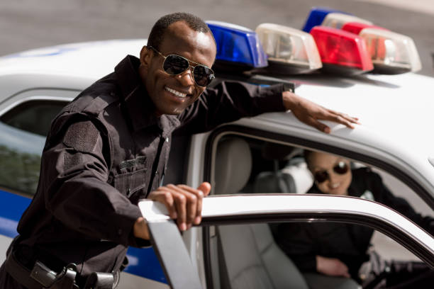 istock happy young police officers with car looking at camera 1007724360