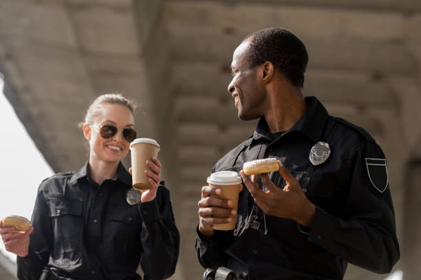 istock young police officers having coffee break with doughnuts 1007727000