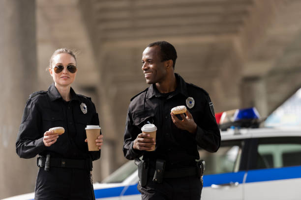 istock smiling police officers having coffee break with doughnuts 1007727328