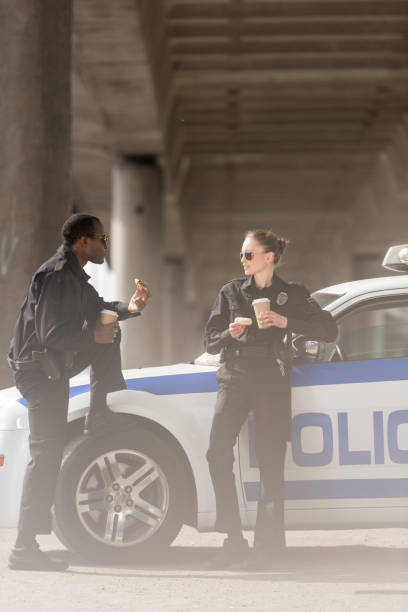 istock police officers with coffee and doughnuts standing next to car under bridge 1007730910