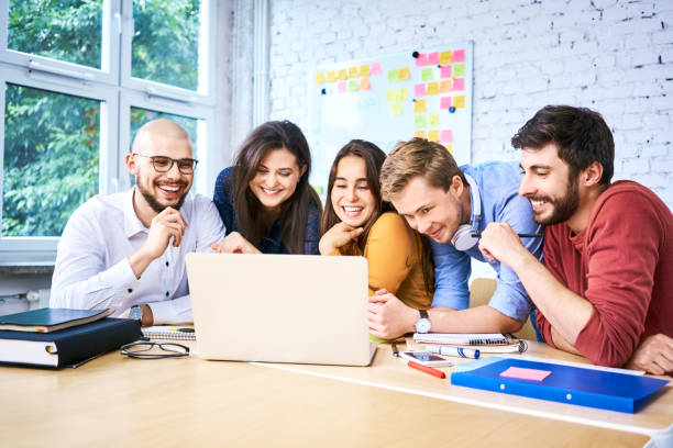 istock Cheerful students looking at laptop while studying together. Group of startup entrepreneurs during work 1007731004