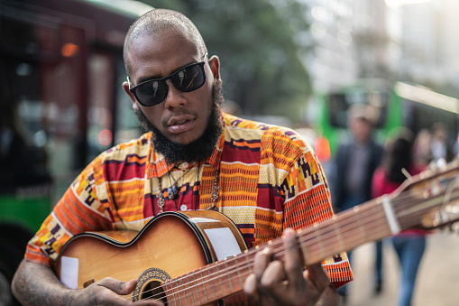 Lisbon, Portugal - January 2, 2015: A street musician plays a guitar in the Rua Augusta street in Lisbon downtown.