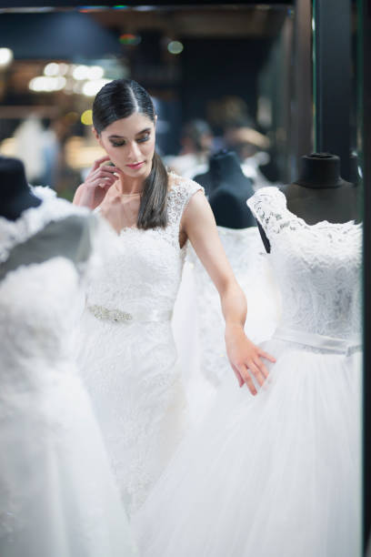 istock Young bride looking wedding dresses in a bridal shop 1007754064