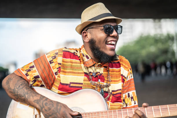 portrait of afro descent smiling and playing guitar - men artist guitarist guitar imagens e fotografias de stock