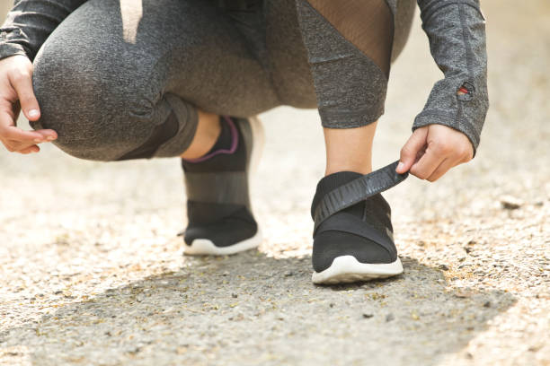 istock Female runner tying her shoes 1007757110