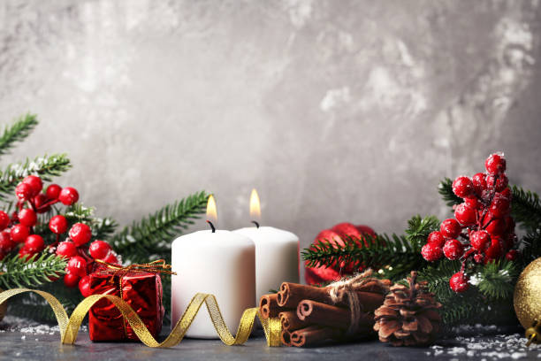 istock Christmas candles with fir-tree branches and berries on wooden table 1007757420