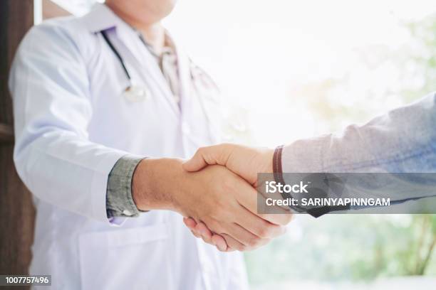 Confident Doctor Shaking Hands With Patients Talk In The Hospital Stock Photo - Download Image Now