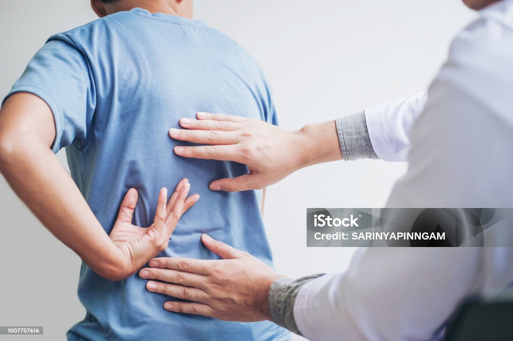Doctor consulting with patient Back problems Physical therapy concept Backache Stock Photo
