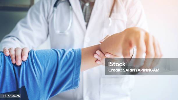 Doctor Consulting With Patient Shoulder Problems Physical Therapy Diagnosing Concept Stock Photo - Download Image Now