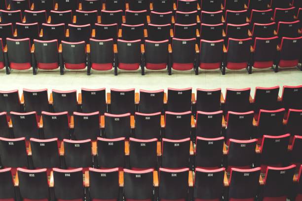 istock Empty comfortable red black seats with numbers in cinema / theater empty seats. 1007757702