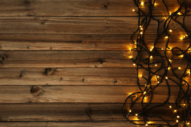 istock Christmas garland lights on brown wooden table 1007757936