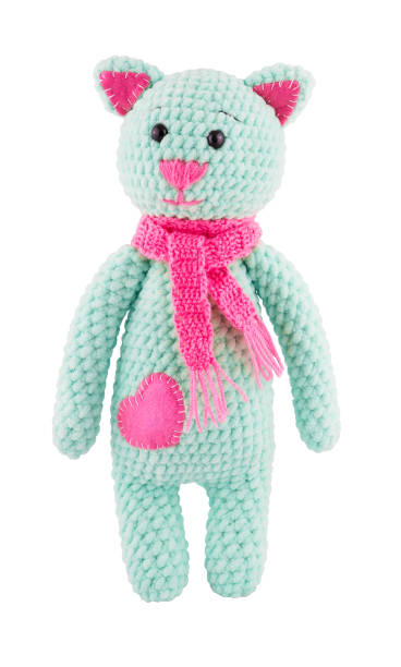 Plush crocheted cat with pink scarf. Soft toy knitted catIsolated on white. Toy cat stock photo