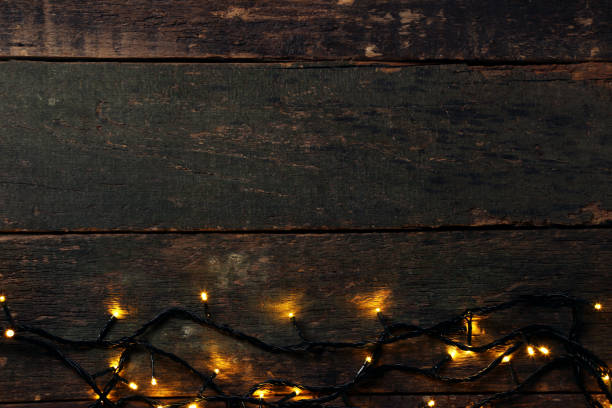 istock Christmas garland lights on grey wooden table 1007762680