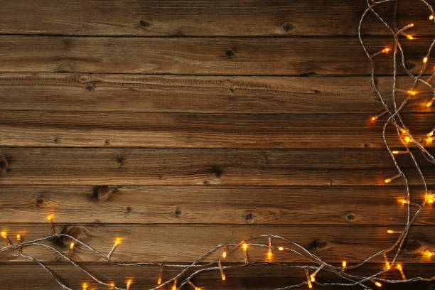 istock Christmas garland lights on brown wooden table 1007763504