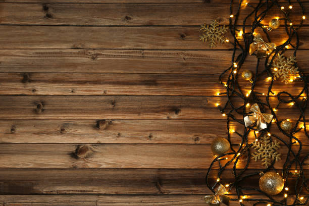istock Garland lights with christmas decorations on brown wooden table 1007763676