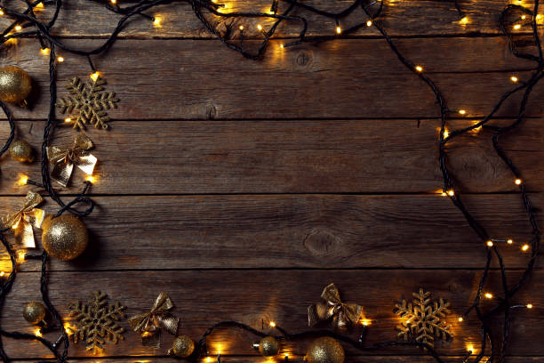 istock Garland lights with christmas decorations on grey wooden table 1007763784