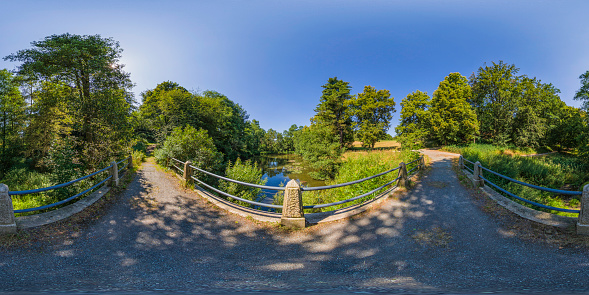 360 degrees spherical panoramic shot of green park in the summer afternoon
