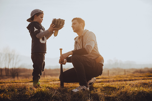 Father and son preparing for a game of softball
