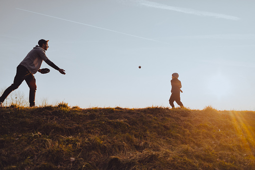 Father with his son playing a game of softball on the field