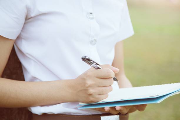 istock young woman holding notebook with pen and writing on the park 1007769748