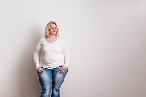 Retrato de una mujer atractiva de la sobrepeso en estudio sobre un fondo blanco. photo