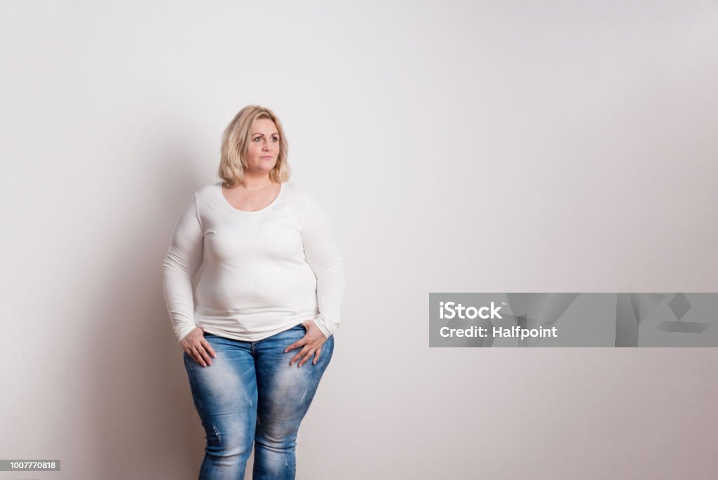 Retrato de una mujer atractiva de la sobrepeso en estudio sobre un fondo blanco. - Foto de stock de Gordo - Complexión libre de derechos