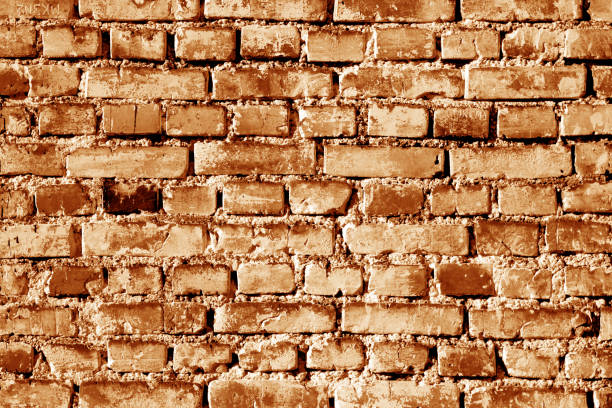 istock Grungy weahered brick wall in orange tone. 1007776518